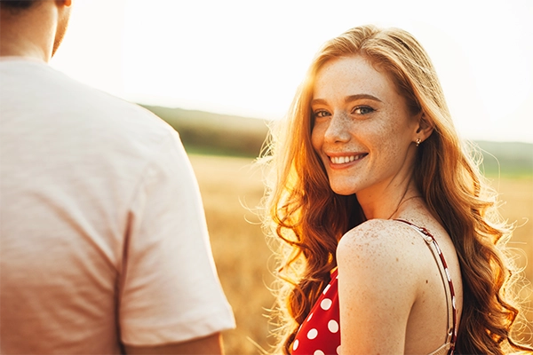 Red hair woman in a field to illustrate the happiness weight loss can bring to someone